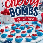 Bright red cherries coated in white chocolate and dipped in blue sanding sugar, on a white plate, with a bowl of cherries and blue coffee mugs in the background.