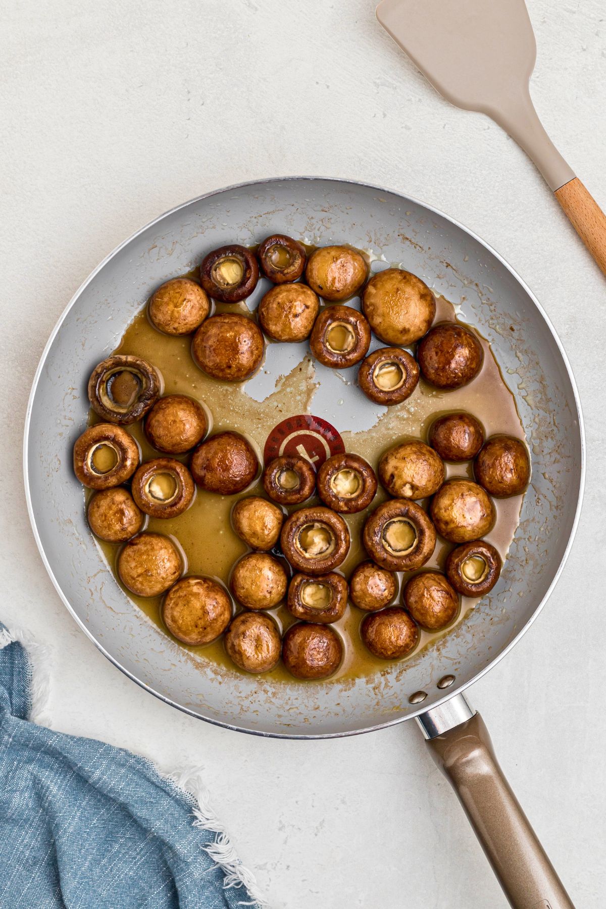 Mushrooms being sauteed in butter in a large saucepan. 