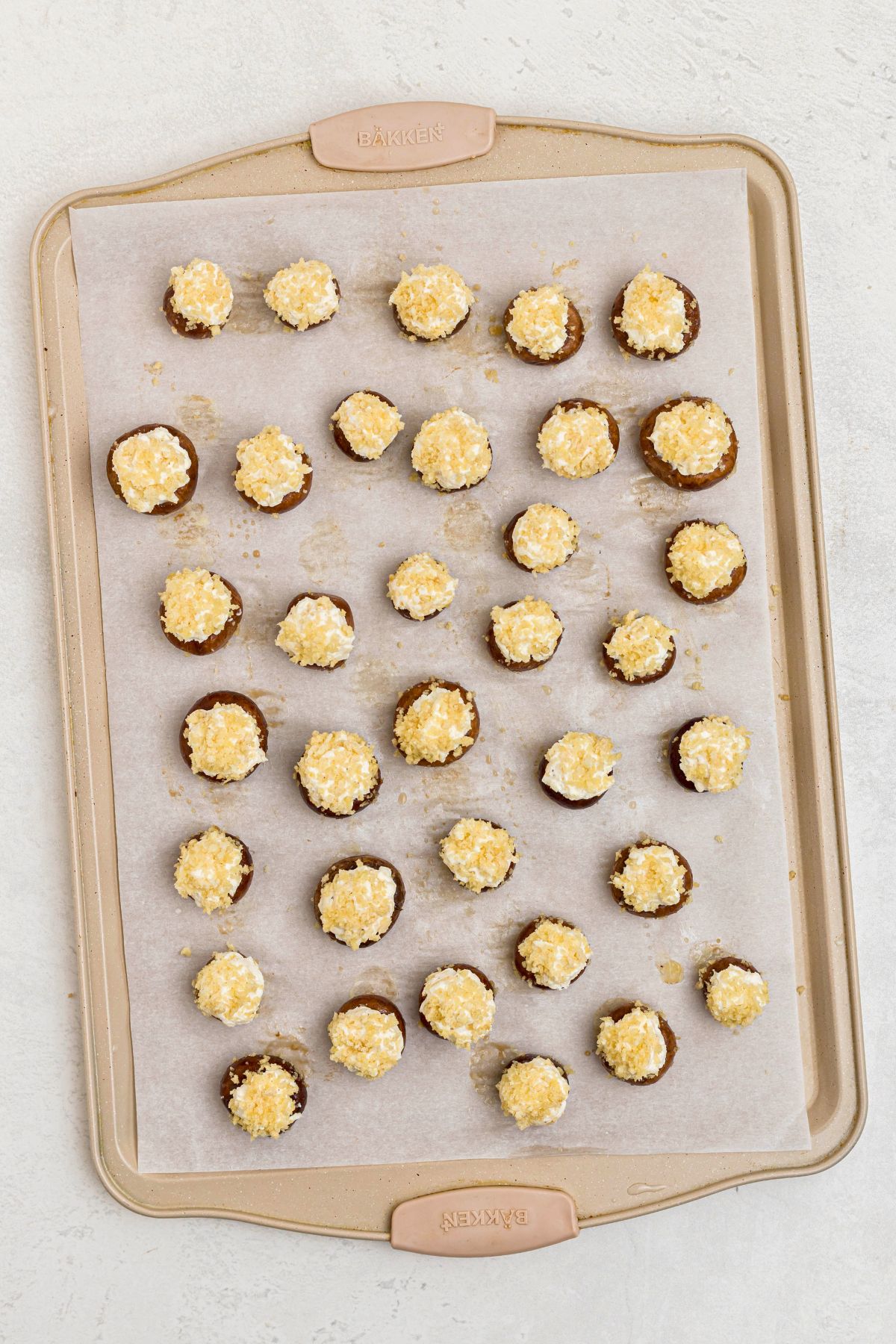 Stuffed mushrooms on a baking sheet, lined with parchment paper.