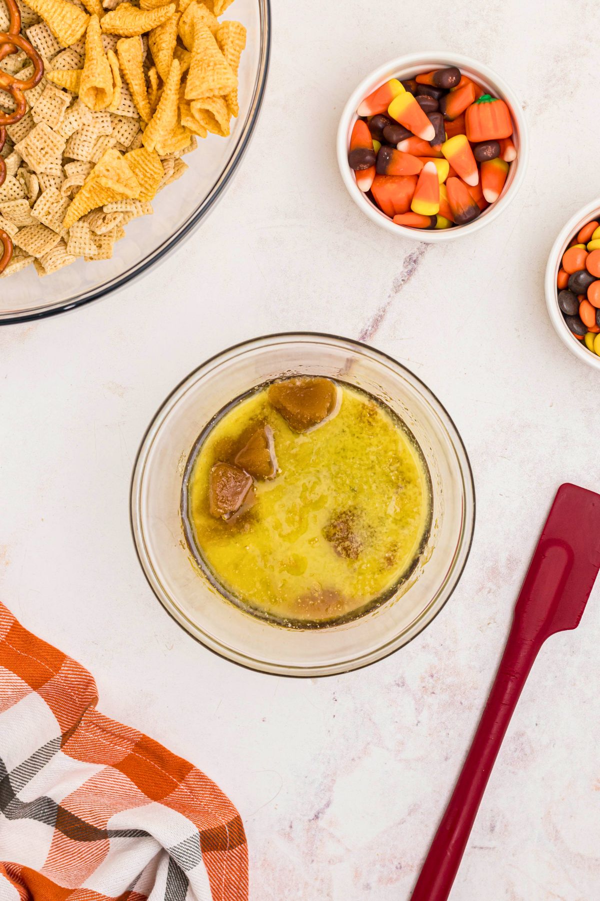 Butter and brown sugar melted together in a clear glass bowl on a marble table. 
