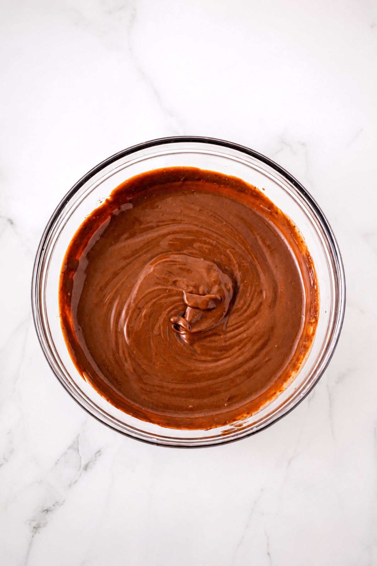 Large clear mixing bowl, filled with pudding mix and milk, mixed together until smooth and creamy.