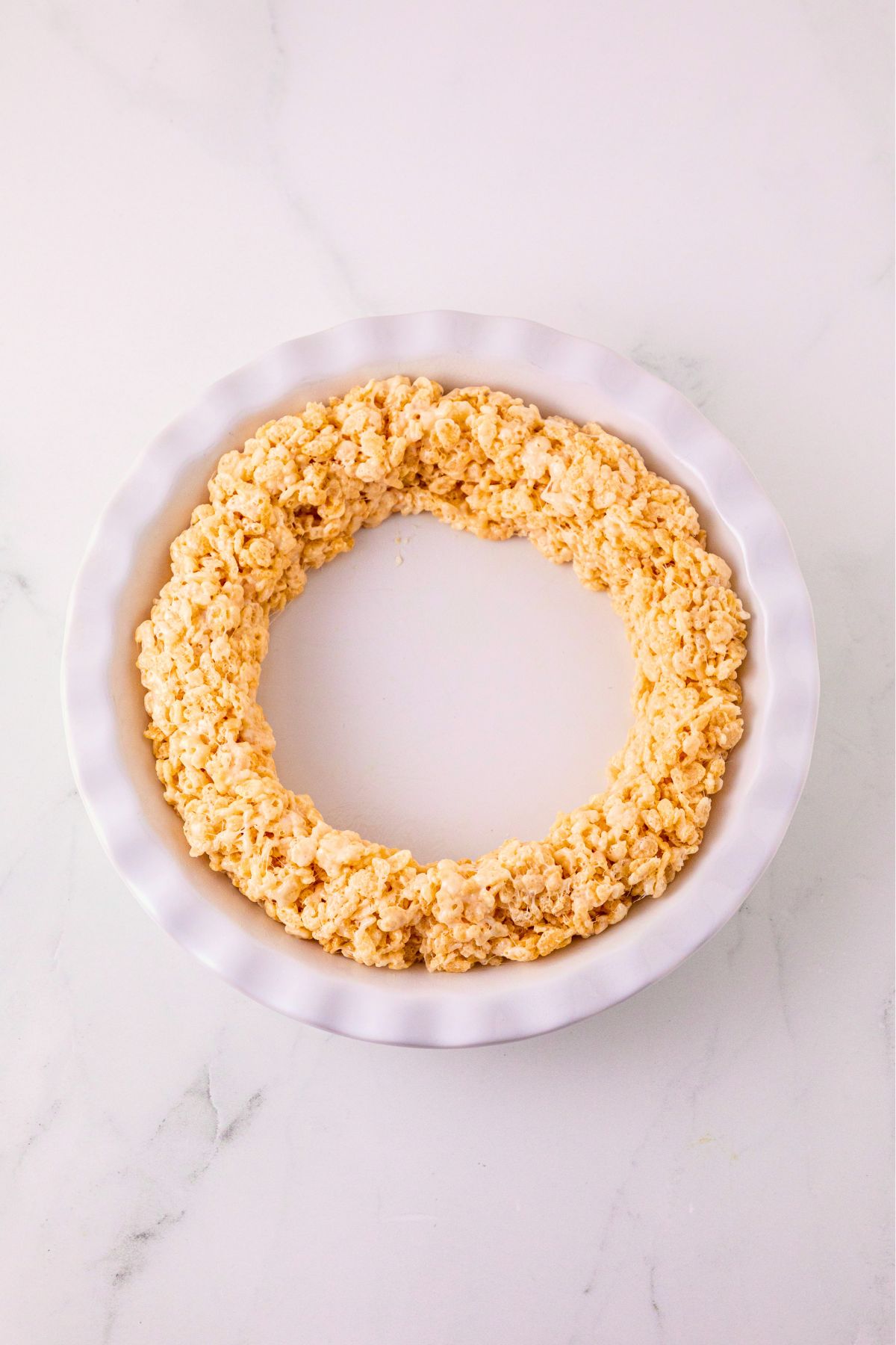 Ring of rice krispies shaped into a ring, presed into a white pie plate. 