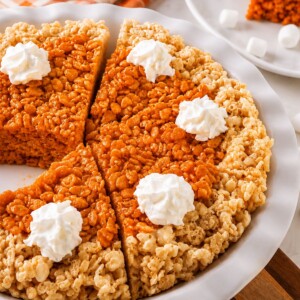Whole pie of krispie treats in a pie plate, after cutting, on a marble table.