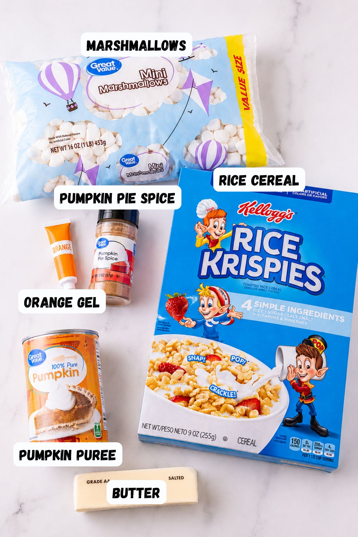 Ingredients needed to make rice krispies, along with pumpkin filling and spice, on a white marble table. 