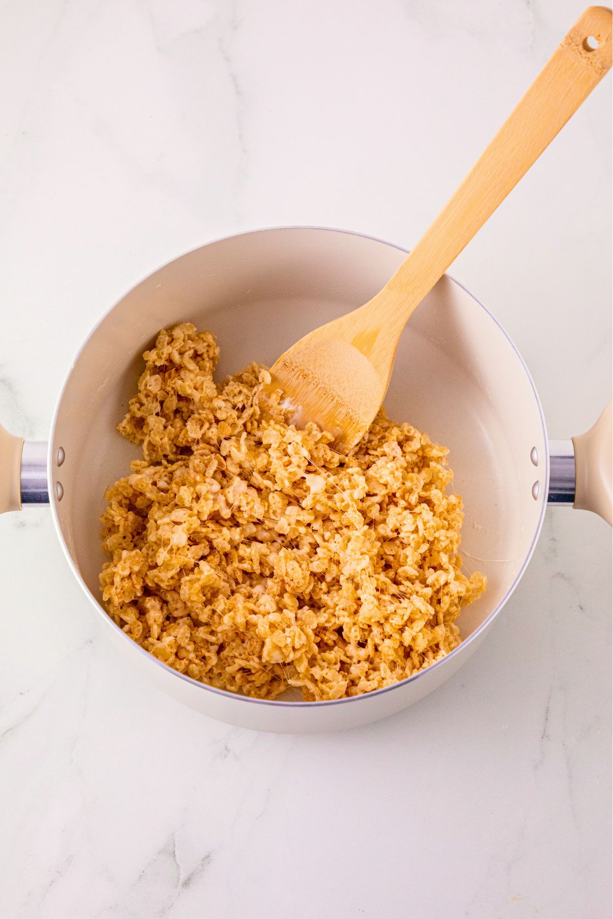 Rice Krispie cereal mixed together in a large saucepan. 