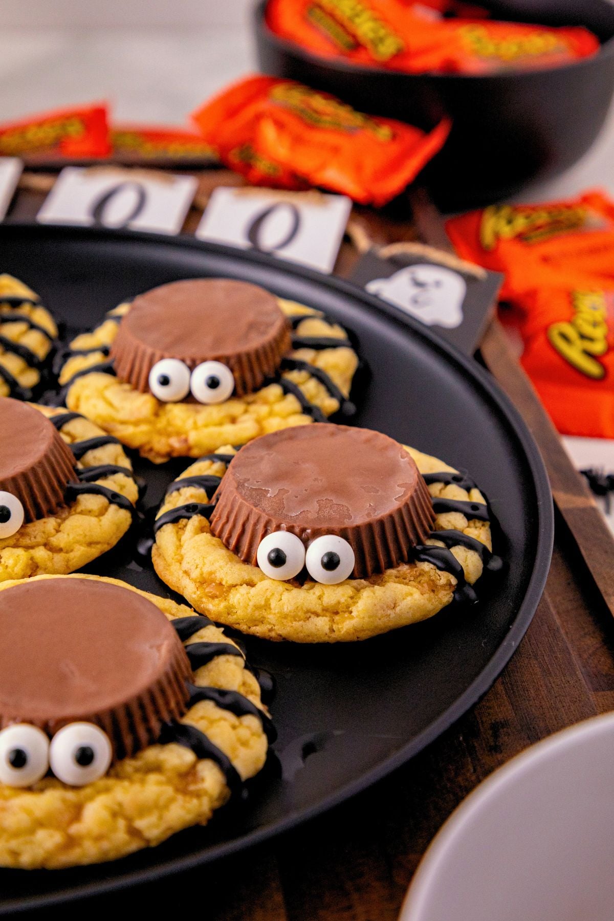 Spider cookies made with cake mix, topped with Reese&rsquo;s peanut butter cups, candy eyes, and chocolate spider legs for an easy Halloween treat.