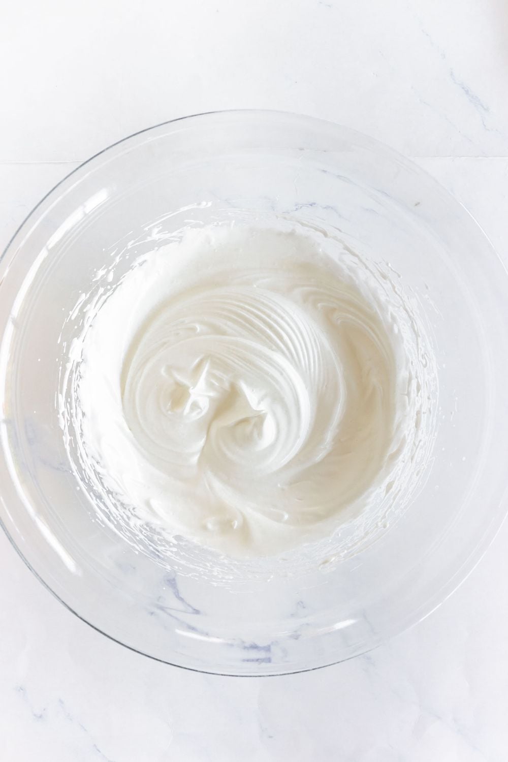 Well whisked egg whites and sugar mixed until light and fluffy in a large glass bowl.