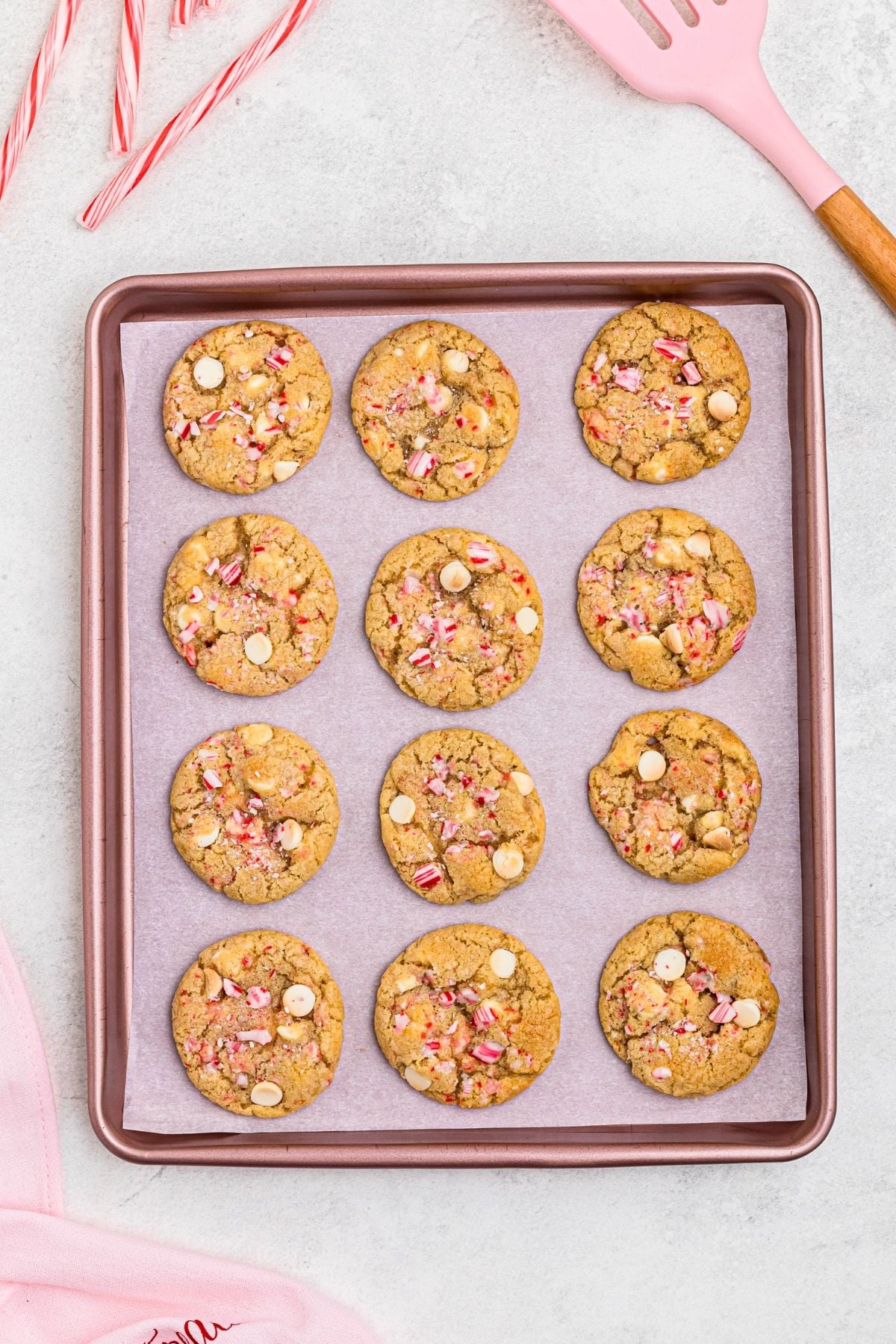 White chip and peppermint cookies on a baking sheet lined with parchment paper. 